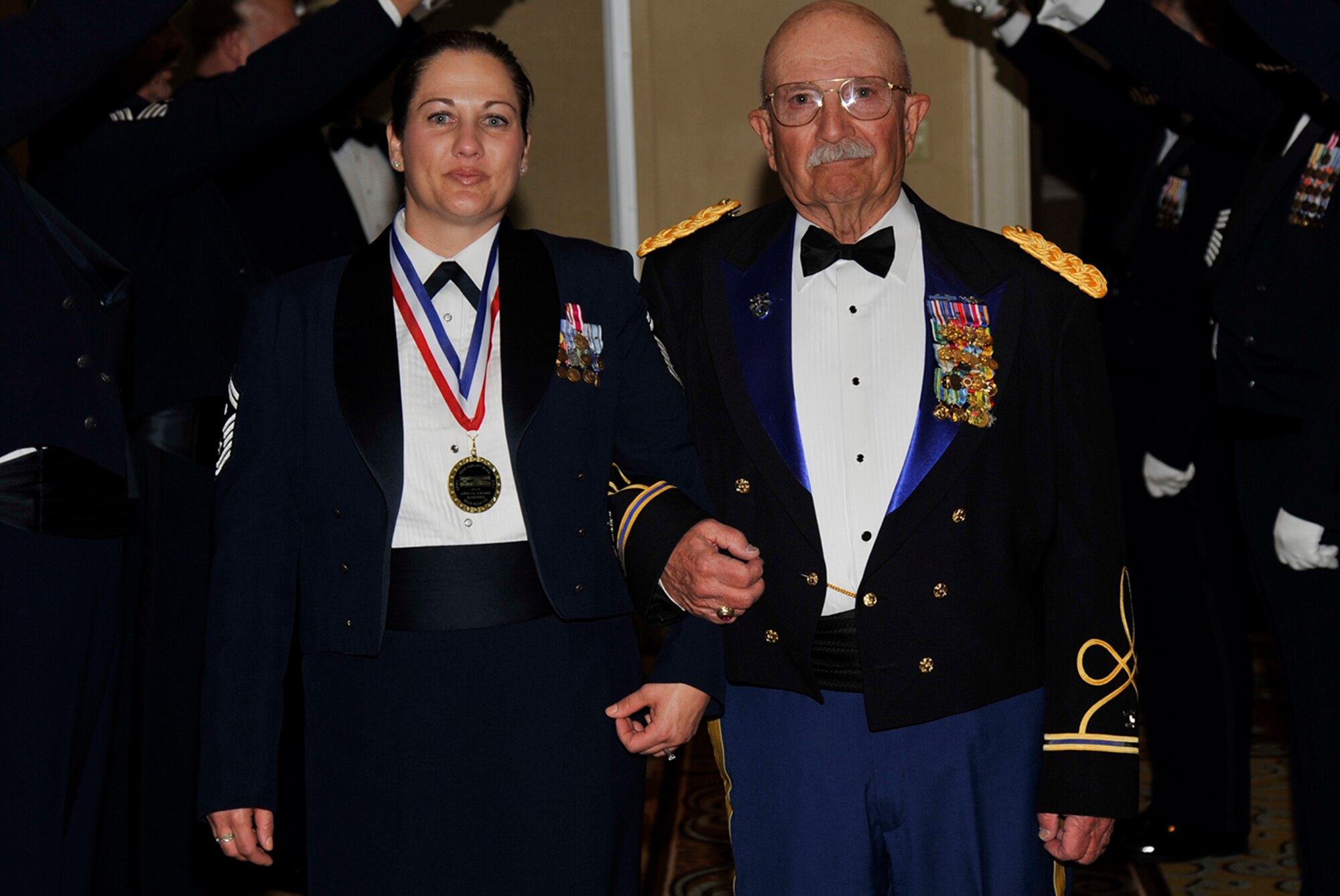 Senior Master Sgt. Sarah Faith, 302nd Aeromedical Staging Squadron First Sergeant enters the 302nd Airlift Wing Annual Awards dinner with retired Army Col. Bill McPherson, March 7, 2015. Faith was named the 302nd AW First Sergeant of the Year. McPherson is the honorary commander of the 302nd ASTS. (U.S. Air Force photo/Rob Lingley) 