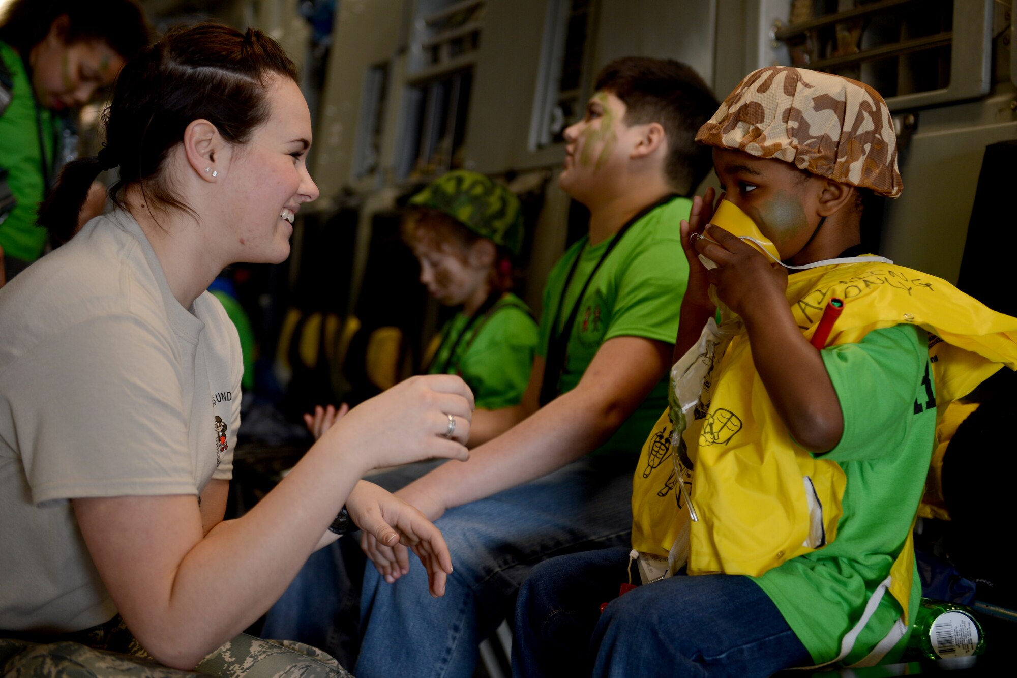 Airman 1st Class Skylar Jones, 4th Airlift Squadron loadmaster, shows a child how to put on a life vest, April 11, 2015, during the Kids Understanding Deployment Operations event at Joint Base Lewis-McChord, Wash. During the event, children learned about some of the squadrons on JBLM such as the 627th Civil Engineer Squadron and the 22nd Special Tactics Squadron. (U.S. Air Force photo/Airman 1st Class Keoni Chavarria)
