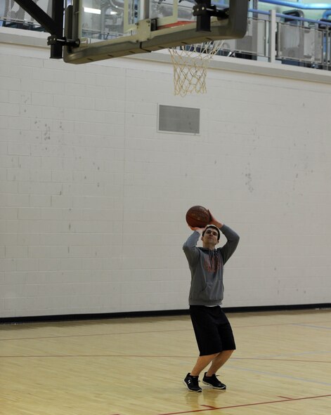 Senior Airman William Kelly, 5th Maintenance Squadron electrical and environmental apprentice plays basketball at the McAdoo Fitness Center after his swing shift on Minot Air Force Base, N.D., April 8, 2015. With the fitness center being open 24 hours a day, Airmen are able to go to the gym at any time of day or night. (U.S. Air Force photo/Senior Airman Kristoffer Kaubisch)