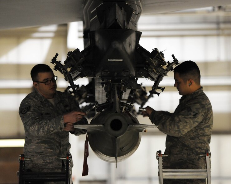 Staff Sgt. Eric Hathaway, 5th Aircraft Maintenance squadron weapons load crew team chief and Senior Airman Chaz Geurrero, 5th aircraft maintenance squadron weapons load crew member secure a MJ-1 bomb onto a B-52H Stratofortress on Minot Air Force Base, N.D., April 8, 2015. The 5th AMXS weapons section is responsible for ensuring the reliability and safe handling of all explosive devices or countermeasures loaded on the B-52H Stratofortress. (U.S. Air Force photo/Senior Airman Kristoffer Kaubisch)