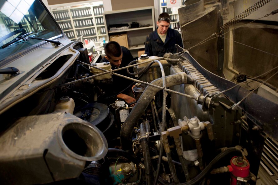 Airman Dalton Bridges, 5th Logistics Readiness Squadron vehicle maintenance apprentice, and Staff Sgt. Chad Berry, 5th Logistics Readiness Squadron vehicle maintenance journeyman, inspect a coolant leak on Minot Air Force Base, N.D., April 8, 2015. 5th LRS is responsible for repairing and maintaining all government owned vehicles on base. (U.S. Air Force photo/Airman 1st Class Sahara L. Fales)