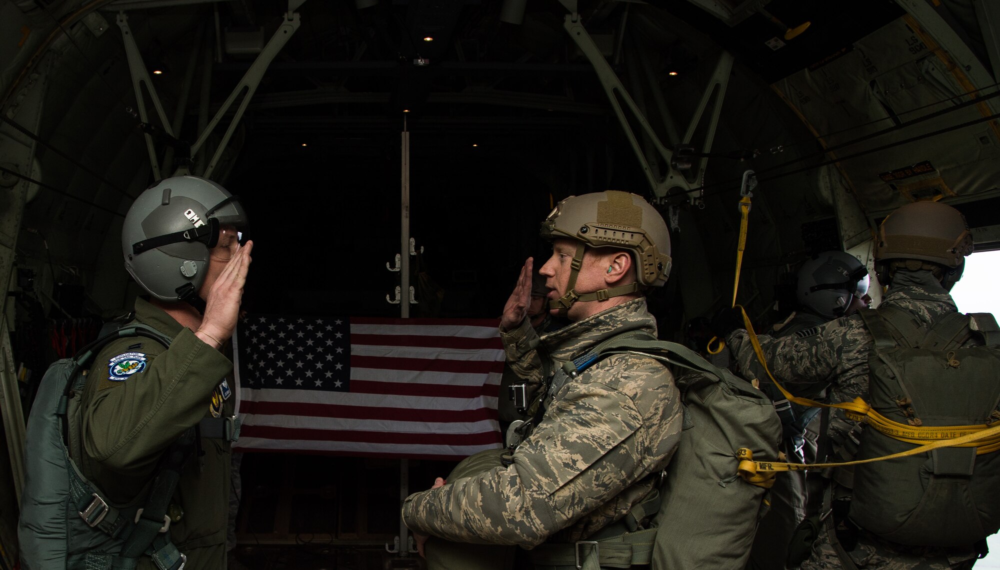Capt. Jason Robinson, 37th Airlift Squadron flight commander, re-enlists Master Sgt. James Burke, 435th Contingency Response Group airfield manager, while flying in a C-130J Super Hercules April 8, 2015 above Powidz Air Base, Poland. While deployed to Poland for training, Burke re-enlisted into the Air Force on a C-130J before parachuting out. (U.S. Air Force photo/Senior Airman Jonathan Stefanko)