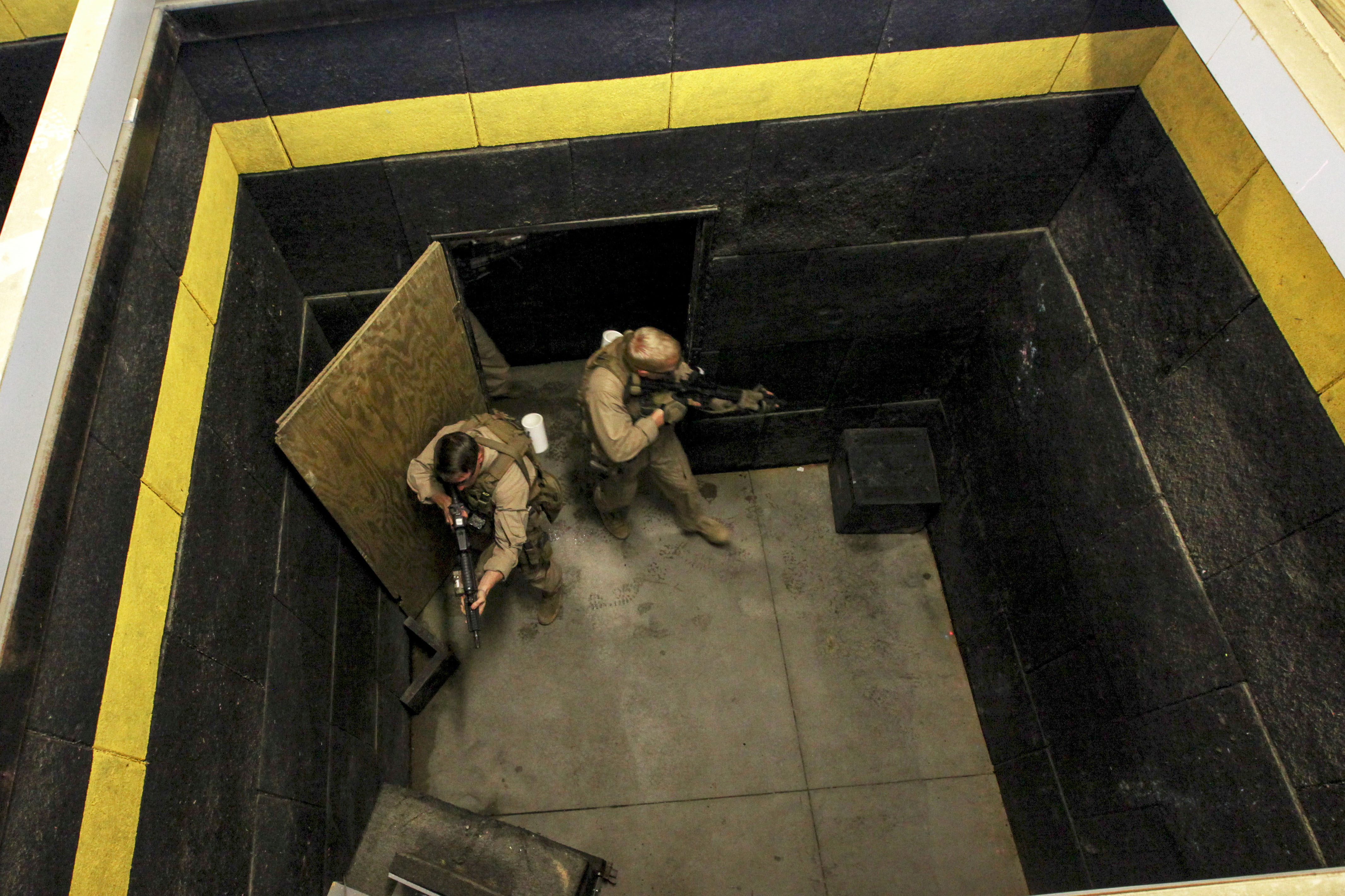 Marines conduct livefire room clearing drills at a shoot house on Fort