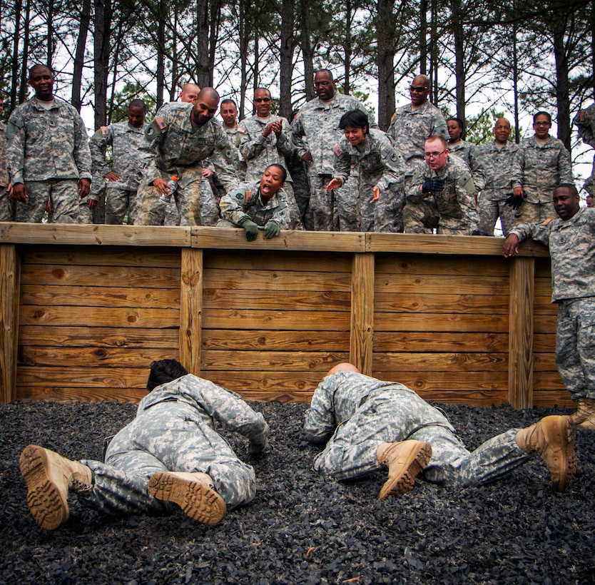 Reserve soldiers cheer on two fellow soldiers as the pair low-crawls to the finish line at the conclusion of a team-building confidence course on Fort Jackson, S.C., April 12, 2015. 
