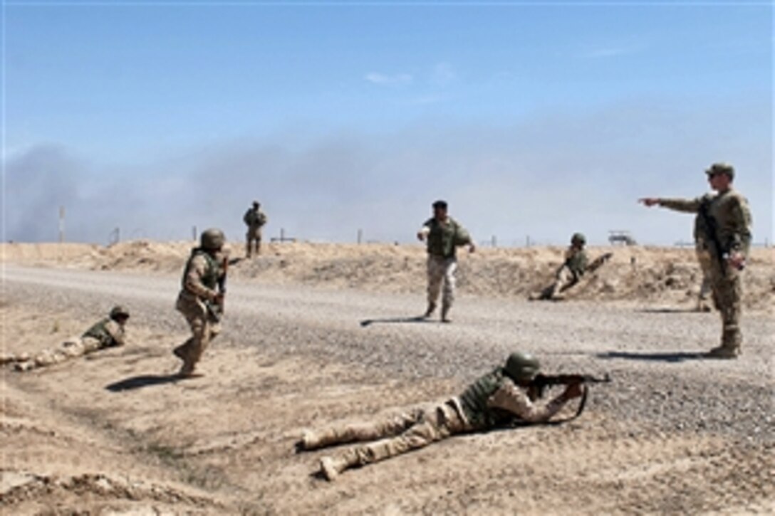 A U.S. soldier, standing right, provides instructions for Iraqi soldiers rehearsing bounding movements on Besmaya Range Complex in Iraq, April 7, 2015. The U.S. soldiers are assigned to the 82nd Airborne Division's 2nd Battalion, 505th Parachute Infantry Regiment, 3rd Brigade Combat Team. They are training Iraqi soldiers with the 75th Brigade, 16th Division to increase the Iraqi division’s combat proficiency and build military capacity in support of Operation Inherent Resolve.