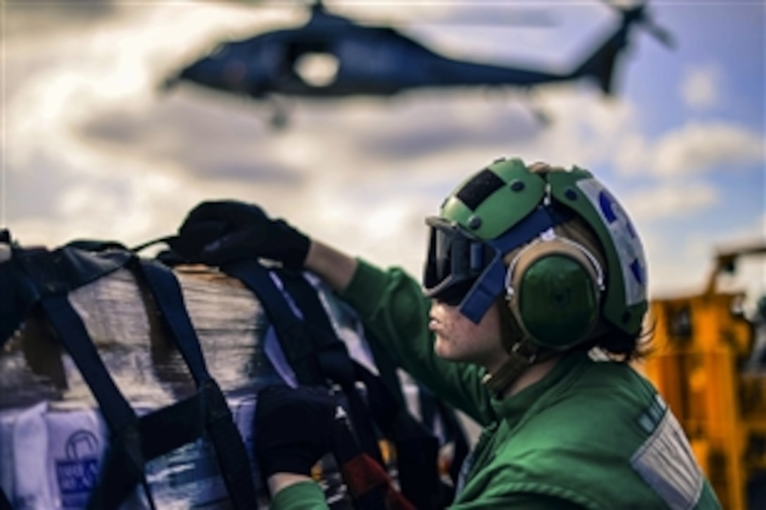 U.S. Navy Seaman Kirsten Zapata removes a cargo net from a crate during a replenishment at sea aboard the USS John C. Stennis in the Pacific Ocean, April 10, 2015. The ship is undergoing an assessment of its abilities to conduct combat missions, perform support functions and survive complex casualty control situations.