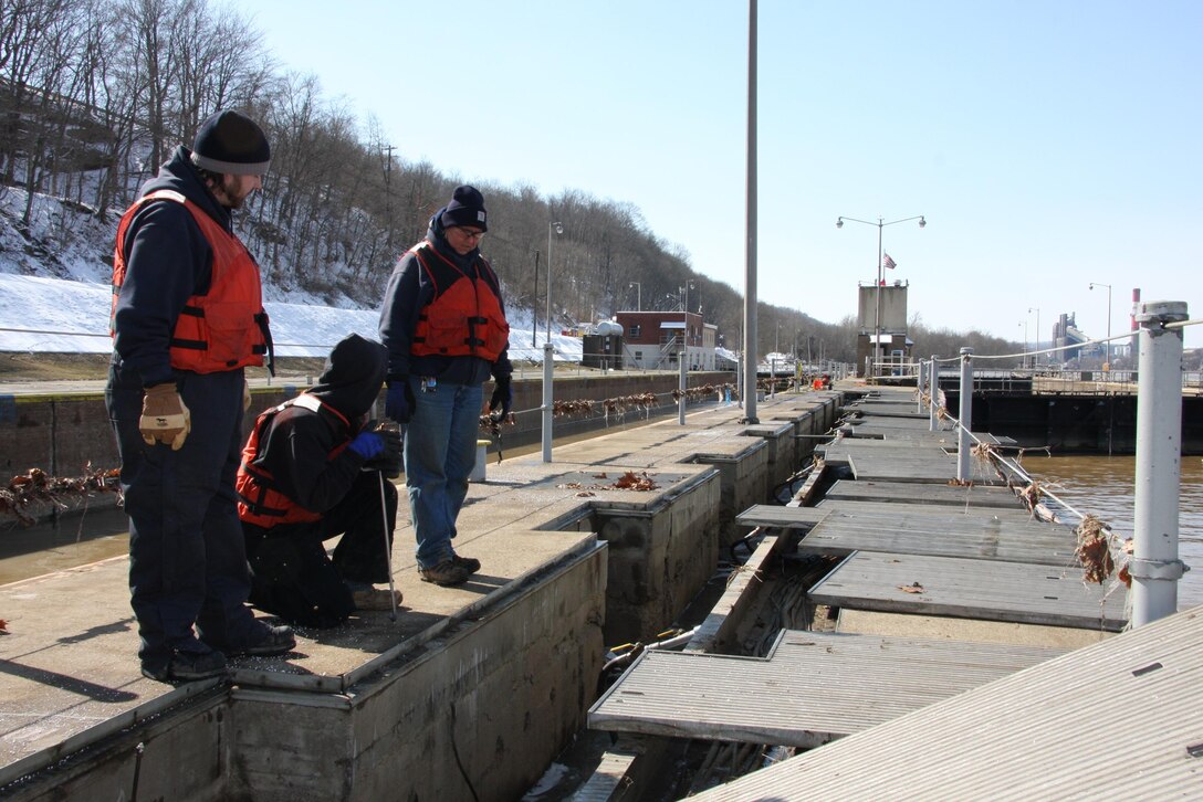 Chris Povich, lock operator, power washes the lock wall to remove mud and debris following the recent high water event at Monongahela River Locks and Dam 4 at Charleroi, March 7.
