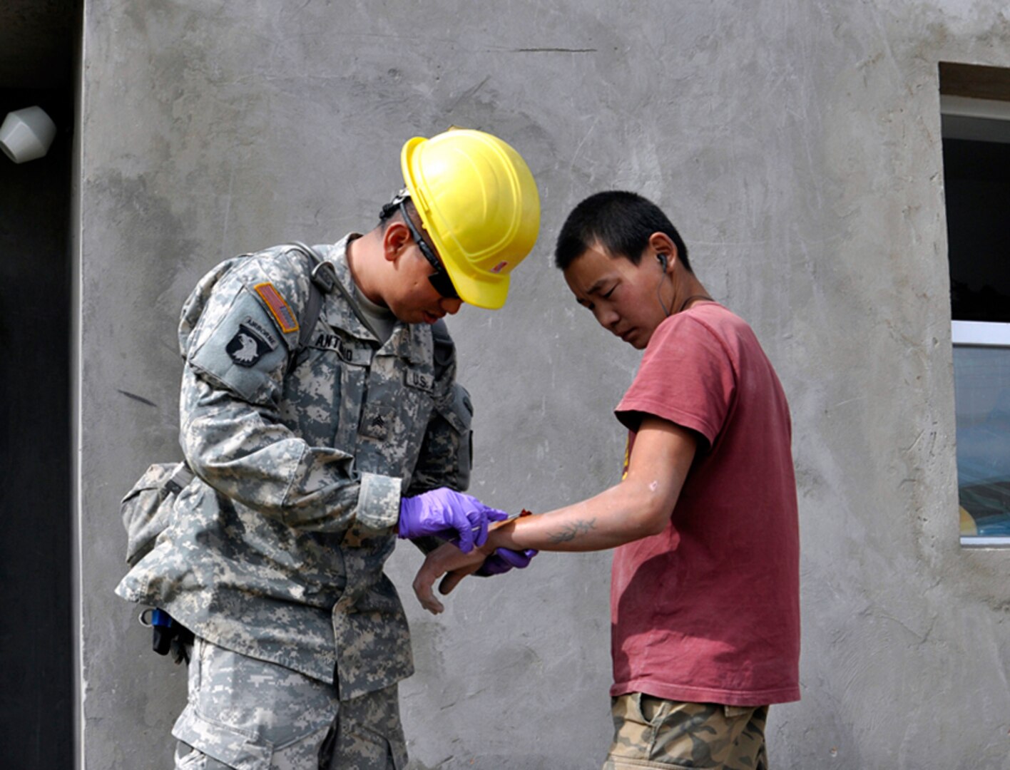 Sgt. Edward Antonio, a medic with the Alaska Army National Guard’s 297th Military Police Company, from Juneau, Alaska treats a cut on the arm of Sgt. Galbadrehk Galae, Mongolia Armed Forces, in the Songinokhairkhan district of Ulaanbaatar, Mongolia Aug. 16. Sgt. Antonio is working with the 797th Engineering Company (Vertical) from Barrigada, Guam and the Mongolian Armed Forces during Khaan Quest 2010. Sgt Antonio’s is responsible for providing medical support to both US and Mongolian participants.