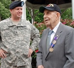 Sgt. James Ader of the New York Army National Guard's 501st Ordnance Battalion congratulates John Sidur after he was presented long overdue recognitions 65 years after his actions in the Pacific during WWII.