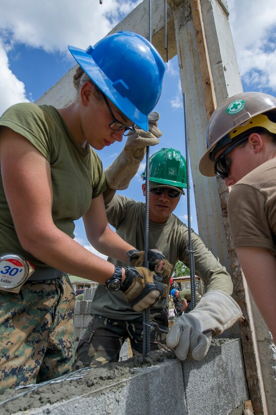 Armed Forces of the Philippines Army Pvt. Oliver V. Clerigo, center, binds rebar with U.S. Marine Lance Cpl. Dana Deline, assigned to the 9th Engineer Support Battalion, and Steelworker Constructionman Andrea Hutcherson, right, assigned to Naval Mobile Construction Battalion 5 at Don Joaquin Artuz Memorial Elementary School in Tapaz, Philippines, during Balikatan 2015, April 12. The engineers, along with U.S. Navy Seabees from Naval Mobile Construction Battalion 5, are part of the Joint Civil-Military Operations Task Force on the island of Panay, which is constructing two classrooms at the school. Balikatan, which means “shoulder to shoulder” in Filipino, is an annual bilateral training exercise aimed at improving the ability of Philippine and U.S. military forces to work together during planning, contingency, humanitarian assistance and disaster relief operations.