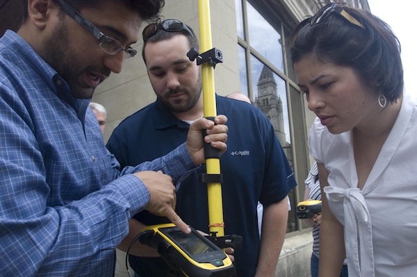 Aras Barzanji (Left), hydraulic engineer at the U.S. Army Corps of Engineers Nashville District, helps Park Rangers Dylon Anderson and Amy Redmond with a practical exercise to use a handheld GPS unit to collect data on Broadway in front of the Estes Kefauver Federal Building in Nashville, Tenn., April 9, 2015.