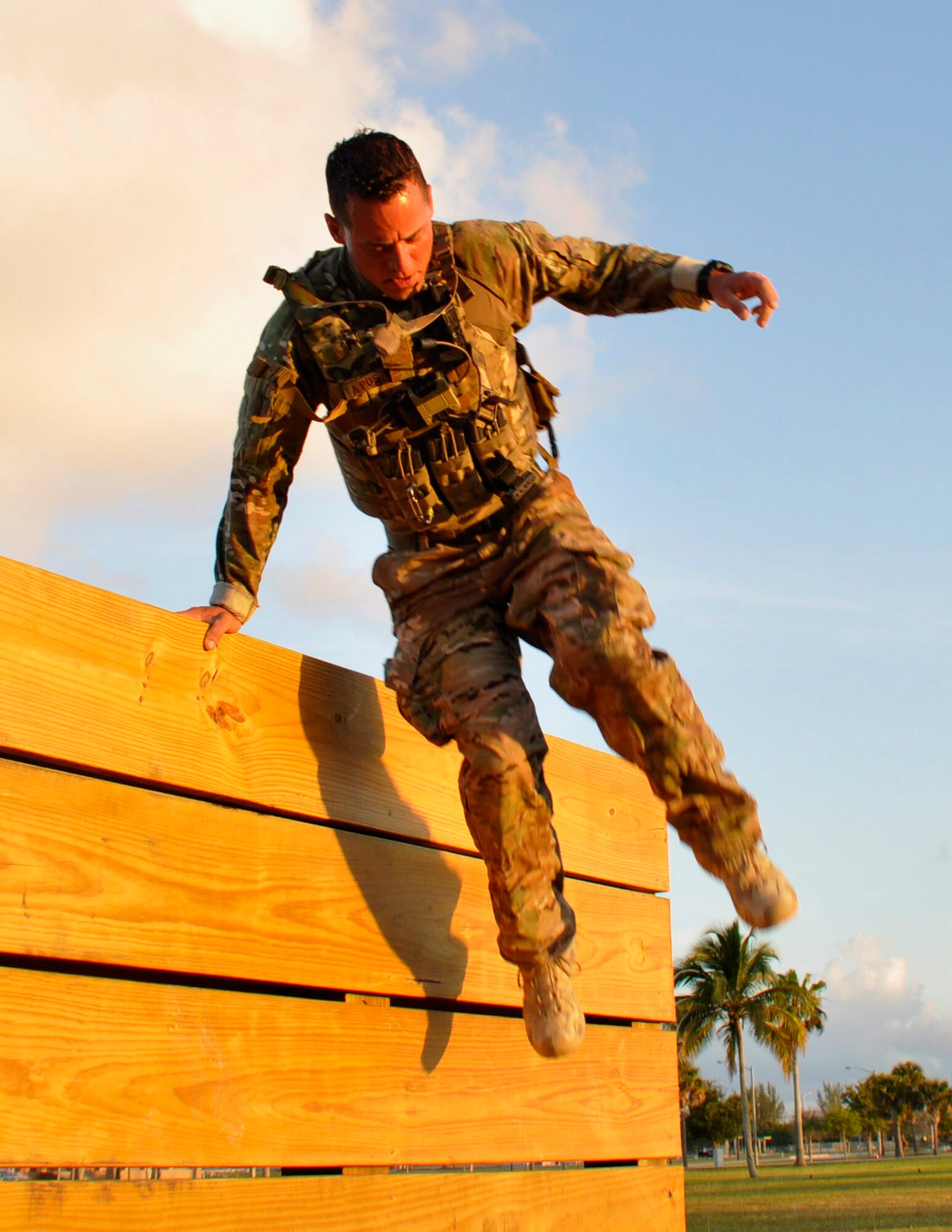 Tech. Sgt. Aaron Johns, Explosive Ordnance Disposal team leader for 482nd Civil Engineering Squadron, jumps over a training obstacle in body armor during a tactical operations physical exercise at Homestead Air Reserve Base, Fla., April 6. This exercise consisted of a three mile ruck, jumping over a six foot wall, and caring roughly 80 pounds of water 100 meters to test the physical stamina of EOD Airmen to ensure they are physically ready for deployments. (U.S. Air Force photo by Senior Airman Aja Heiden)