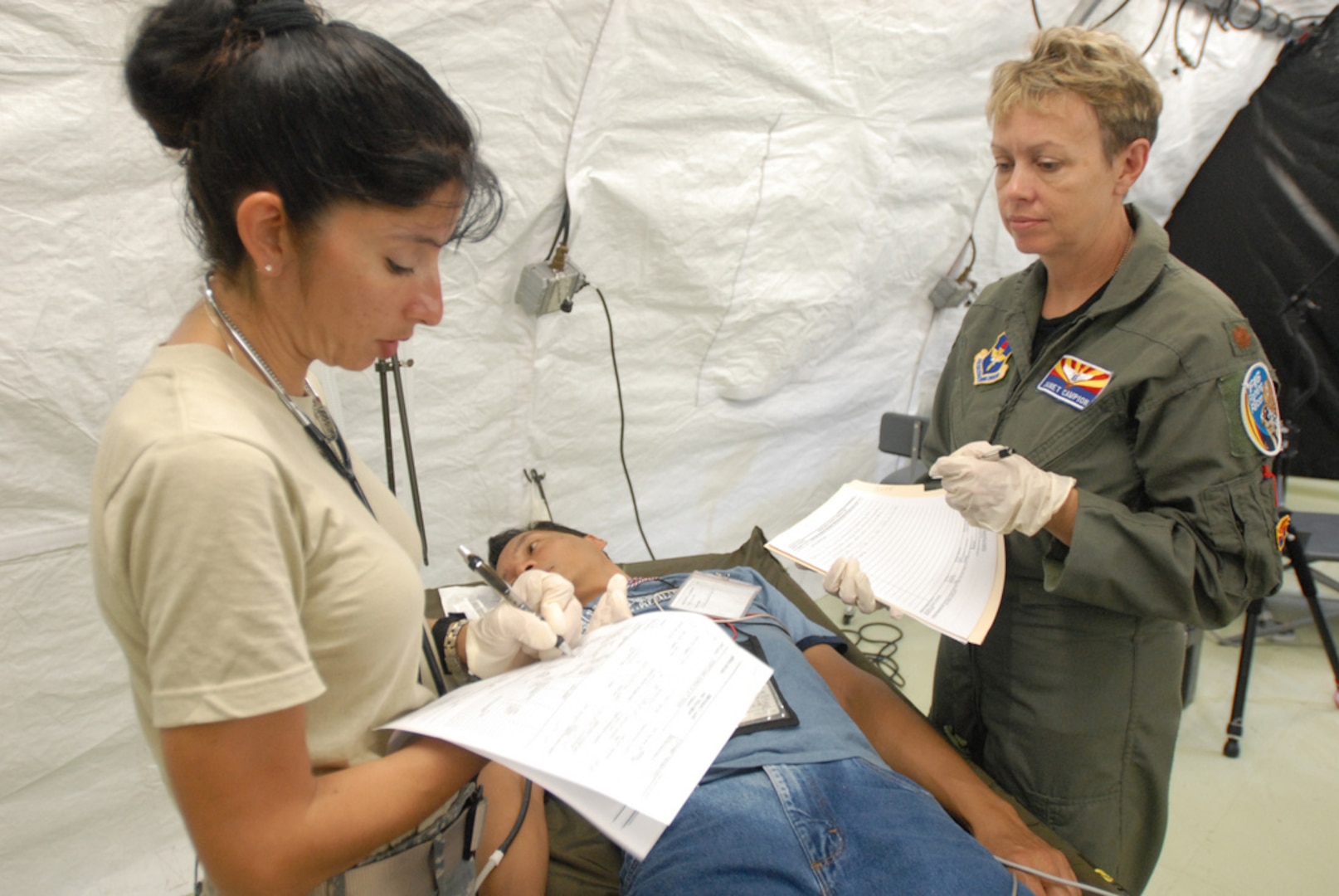 Air Force Lt. Col. Jackie Federico-Lopez, a clinical nurse with the 162nd Medical Group of the Arizona National Guard, and Maj. Janet Campion, a flight surgeon also with the 162nd, evaluate a victim during Vigilant Guard Guam, Aug. 24, 2010. The Airmen are part of the emergency medicine portion of the training exercise.