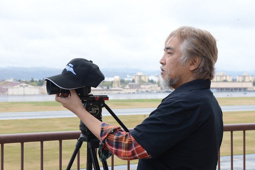A photographer with the Aircraft Owners and Pilots Association-Japan documents the arrival of civilian aircraft attending the Mid-Air Collision Avoidance conference at Yokota Air Base, Japan, April 11, 2015.  The conference is a safety and fly-in training event held every other year for civilian pilots operating in the local area. (U.S. Air Force photo by Airman 1st Class David C. Danford/Released)