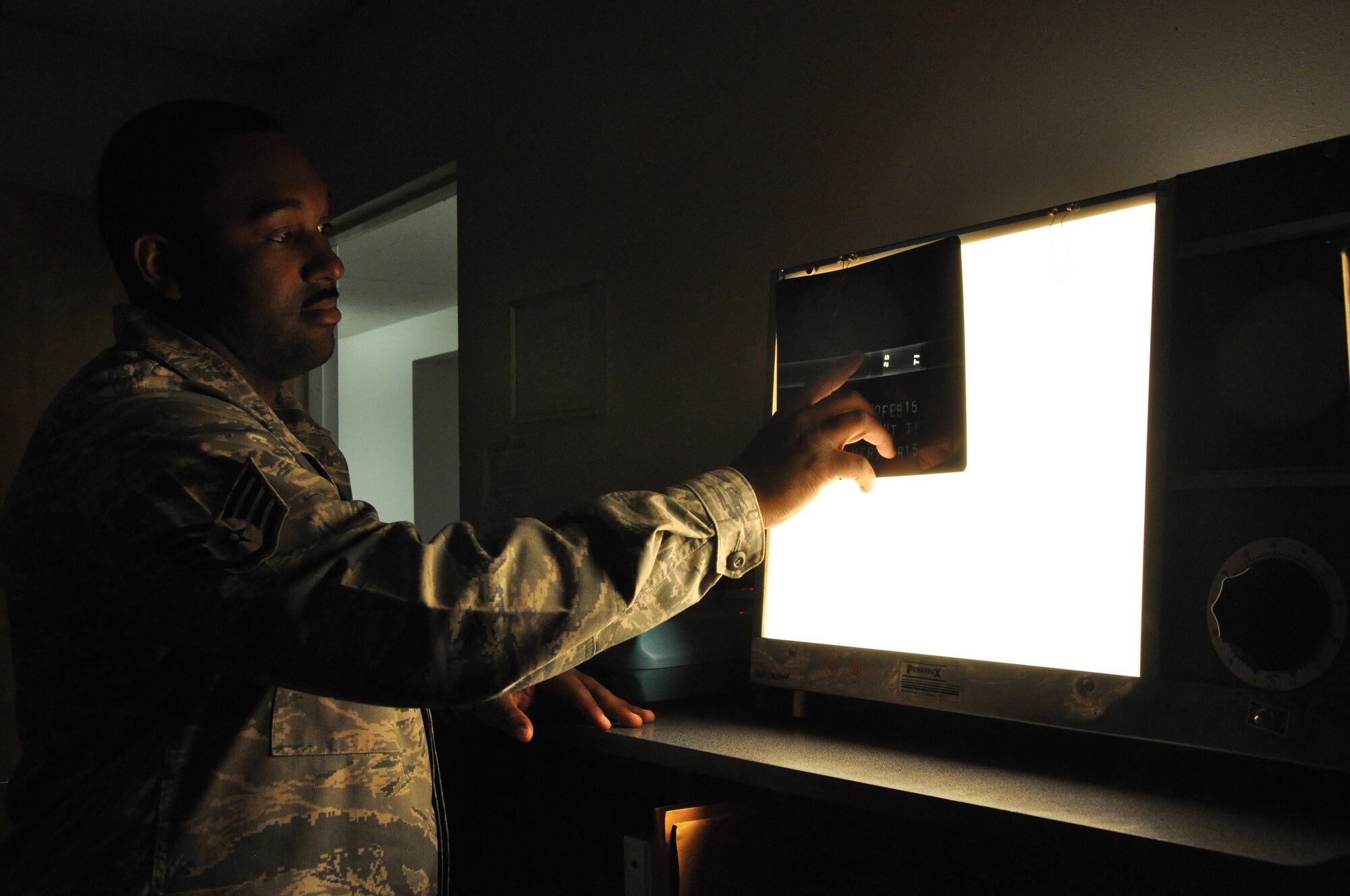 Staff Sgt. Jamal Palmer, 9th Maintenance Squadron non-destructive inspection craftsman, inspects an  x-ray image on a light table at Beale Air Force Base, Calif., April 14, 2015. NDI assesses aircraft structural components for microscopic defects such as cracks and indentations. (U.S. Air Force photo by Airman 1st Class Taylor A. Workman/Released)