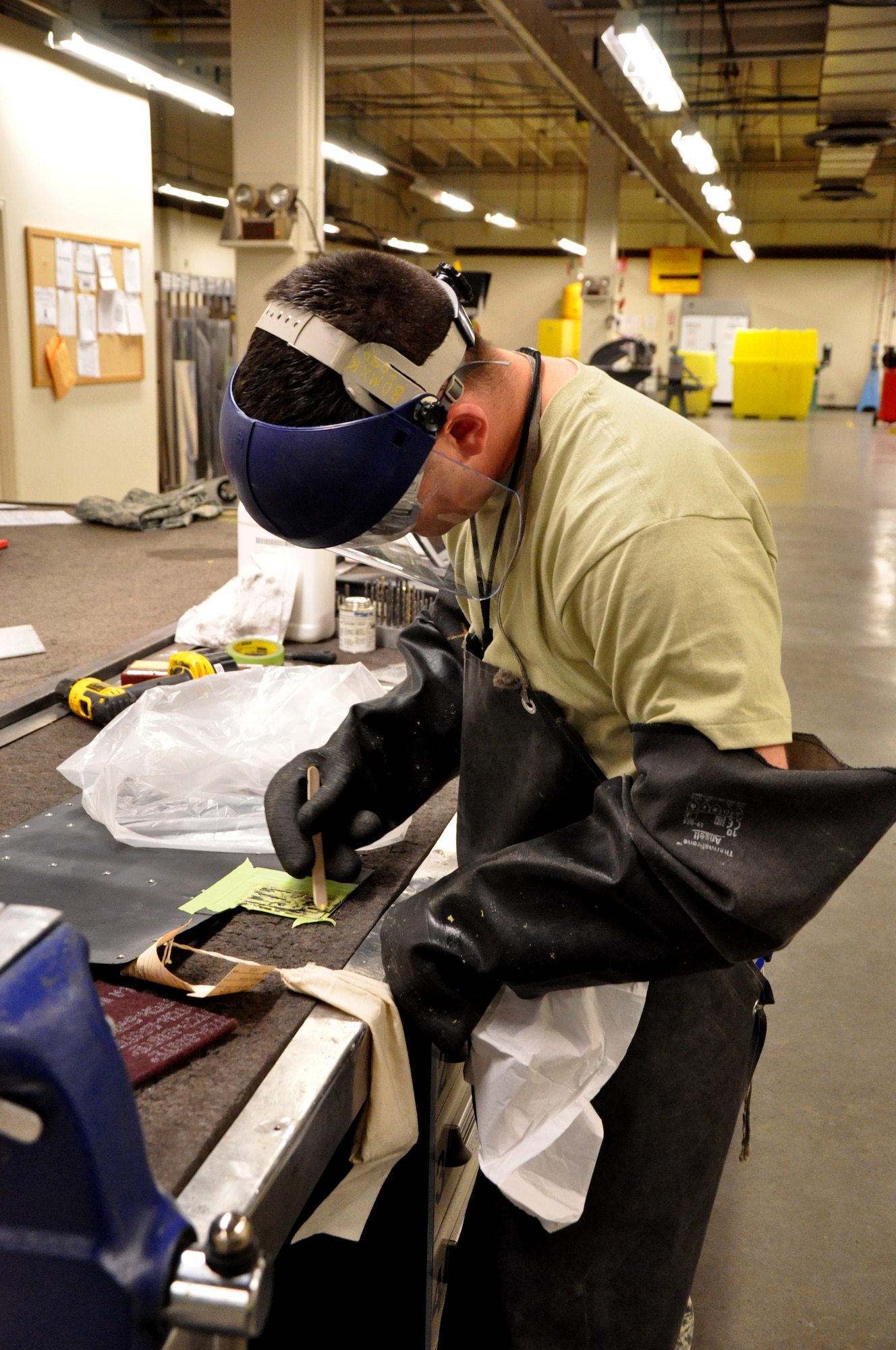 Staff Sgt. James DeNogean, 9th Maintenance Squadron aircraft structural maintenance craftsman, strips the top coat of paint on an access panel with corrosive chemicals at Beale Air Force Base, Calif., April 14, 2015. Multiple layers of proper protection equipment, such as latex and rubber gloves, are utilized when handling these hazardous materials to prevent contact with the skin. (U.S. Air Force photo by Airman 1st Class Taylor A. Workman/Released)