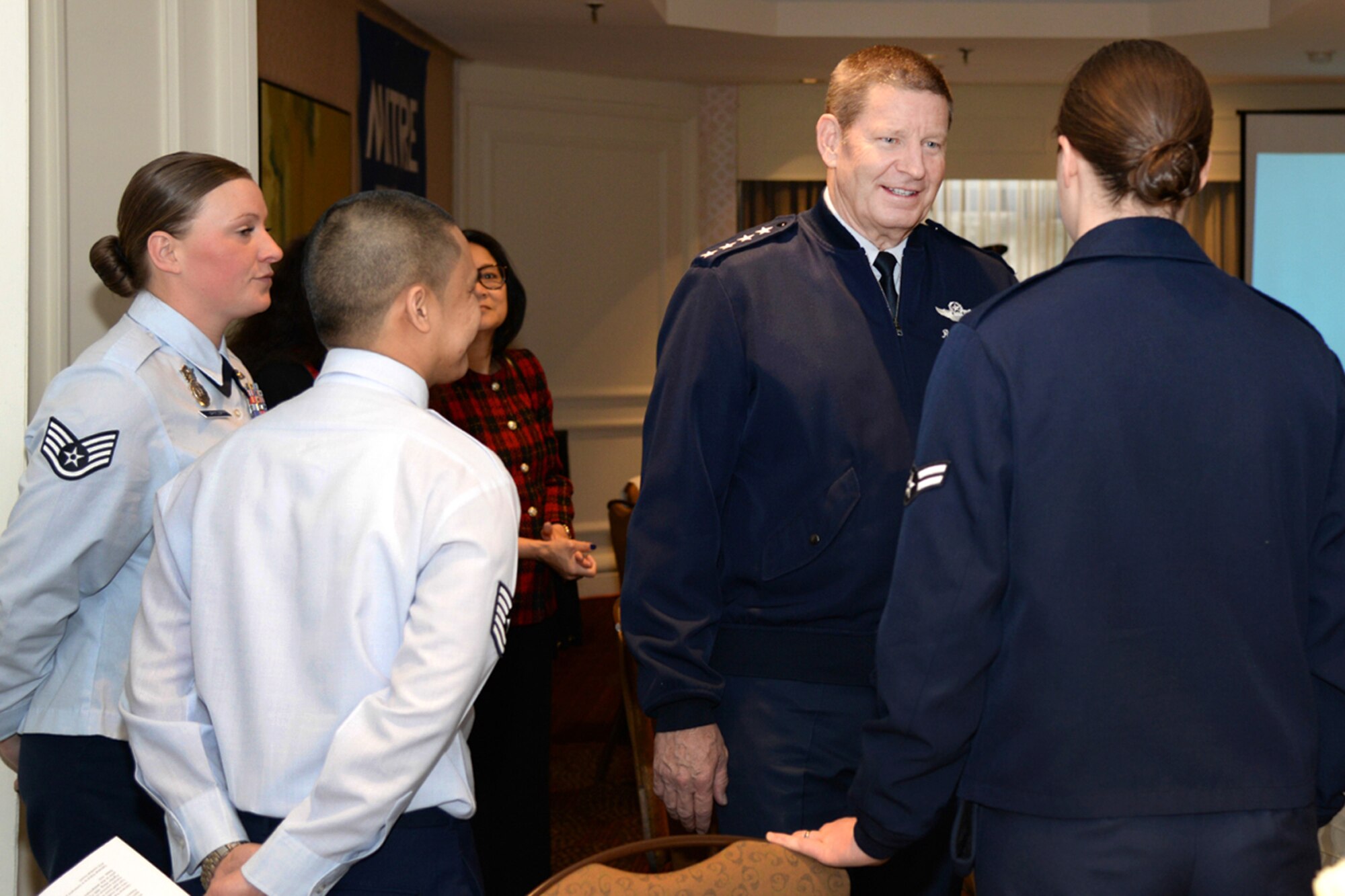 Gen. Robin Rand, commander of Air Education and Training Command, speaks with Airman 1st Class Kara Watts before greeting Tech. Sgt. Eugene Pamplona and Staff Sgt. Michelle Armour from the 66th Air Base Group during a North Suburban Chamber of Commerce breakfast in Bedford, Mass., April 10. Later in the day, the general presented scholarships to ROTC cadets during a luncheon hosted by the Lexington-Concord Chapter of the Armed Forces Communications and Electronics Association and the Association of Old Crows Patriots Roost Chapter. (U.S. Air Force photo by Linda LaBonte Britt) 
