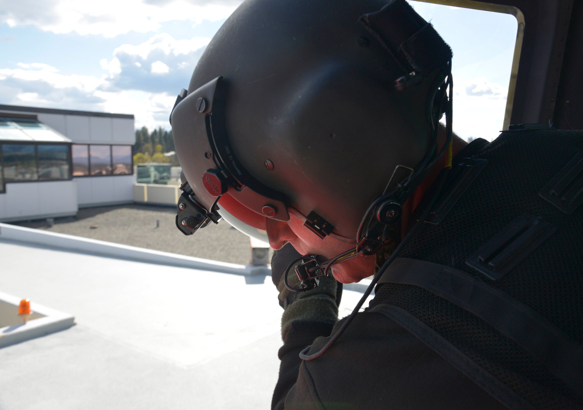Staff Sgt. Chris, 36th Rescue Flight special mission aviator, looks over the landing pad atop Sacred Heart Hospital to drop off a mock survivor during an orientation flight with Col. Brian McDaniel, 92nd Air Refueling Wing commander, April 8, 2015, in downtown Spokane, Wash. McDaniel joined Chris and pilots, Capt. Nate and Maj. Jennings, to familiarize himself with the areas Fairchild Airmen train off base for the full range of military operations conducted here. (U.S. Air Force photo/Senior Airman Janelle Patiño)