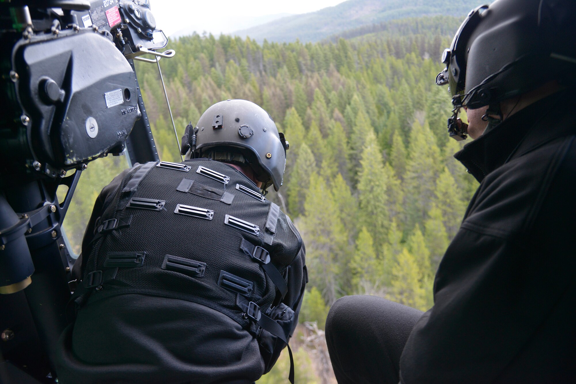 Staff Sgt. Chris, 36th Rescue Flight special mission aviator, works with the pilots to maneuver the UH-1N Iroquois helicopter while Col. Brian McDaniel, 92nd Air Refueling Wing commander, observes during an orientation flight April 8, 2015, at Tacoma Valley, Wash. While the helicopter was in a 150-foot hover, Chris prepared to put the forest penetrator at the simulated survivor's feet to show McDaniel how hoisting procedures work. (U.S. Air Force photo/Senior Airman Janelle Patiño)