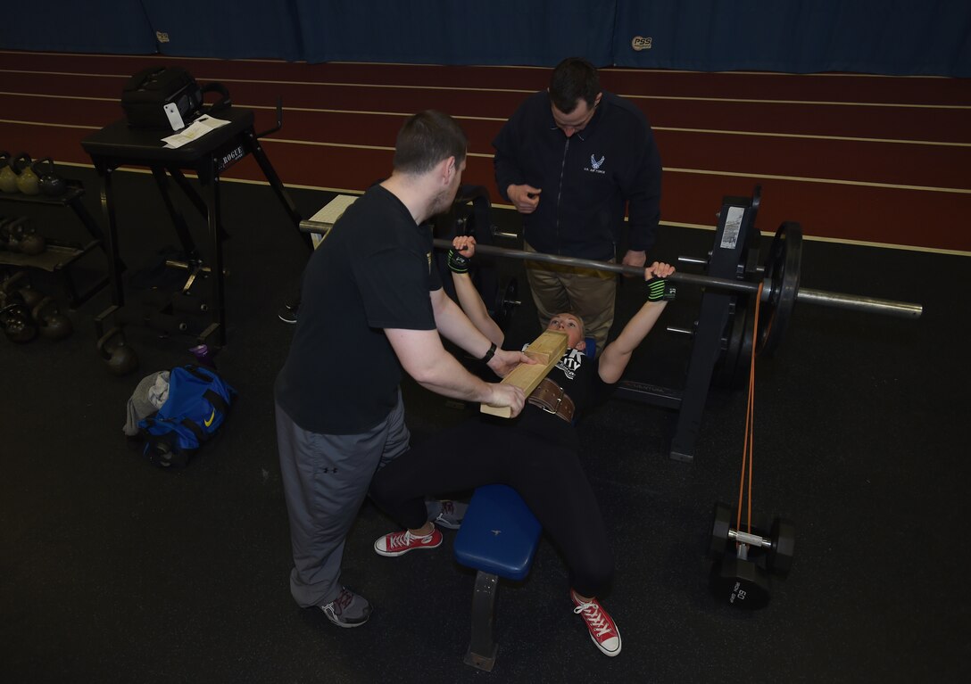 Staff Sgt. April Spilde, U.S. Air Force Honor Guard formal training instructor, performs a board bench press with resistance bands at the West Fitness Center on Joint Base Andrews, Md., March 12, 2015. Spilde, an amateur award- winning powerlifter, prepares for an upcoming meet by training specific ranges of motion in order to increase her overall power for a bigger bench press. (U.S. Air Force photo/ Senior Airman Nesha Humes))