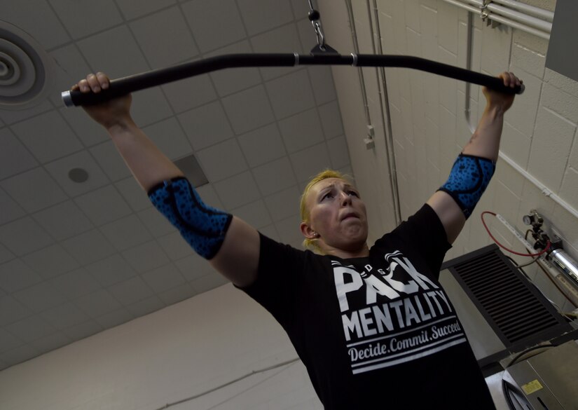 Staff Sgt. April Spilde, U.S. Air Force Honor Guard formal training instructor, exercises using the pull down machine at the West Fitness Center on Joint Base Andrews, Md., March 12, 2015.  Spilde is part of an online, powerlifting community, where she receives personalized work outs in preparation for her first official powerlifting competition.  (U.S. Air Force photo/ Senior Airman Nesha Humes)