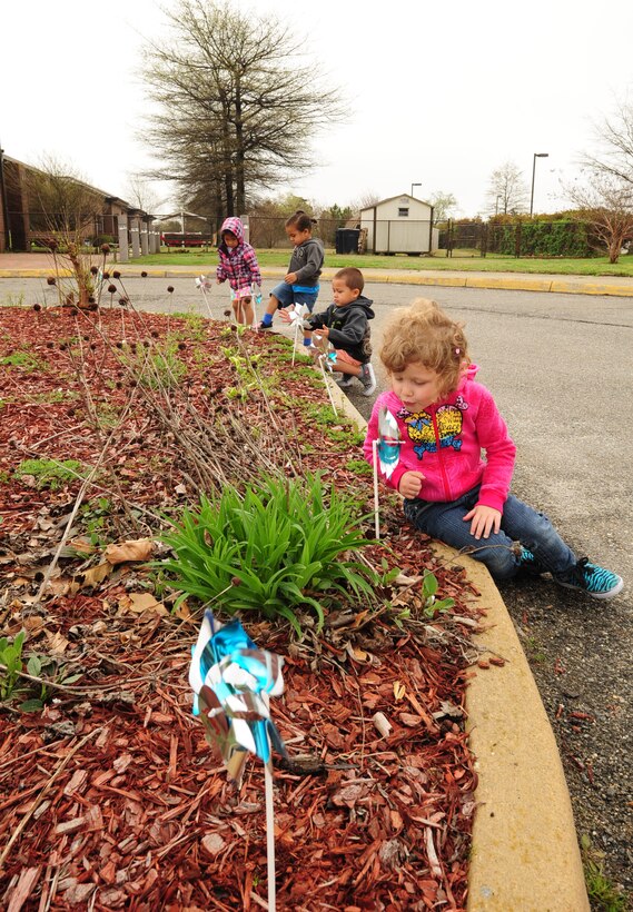 Children from the Langley Air Force Base Child Development Center watch as pinwheels they planted in celebration of Month of the Military Child spin at Langley Air Force Base, Va., April 10, 2015. The Department of Defense observes April as the Month of the Military Child to highlight the contributions, courage and patriotism of military children. (U.S. Air Force photo by Staff Sgt. Natasha Stannard/Released) 