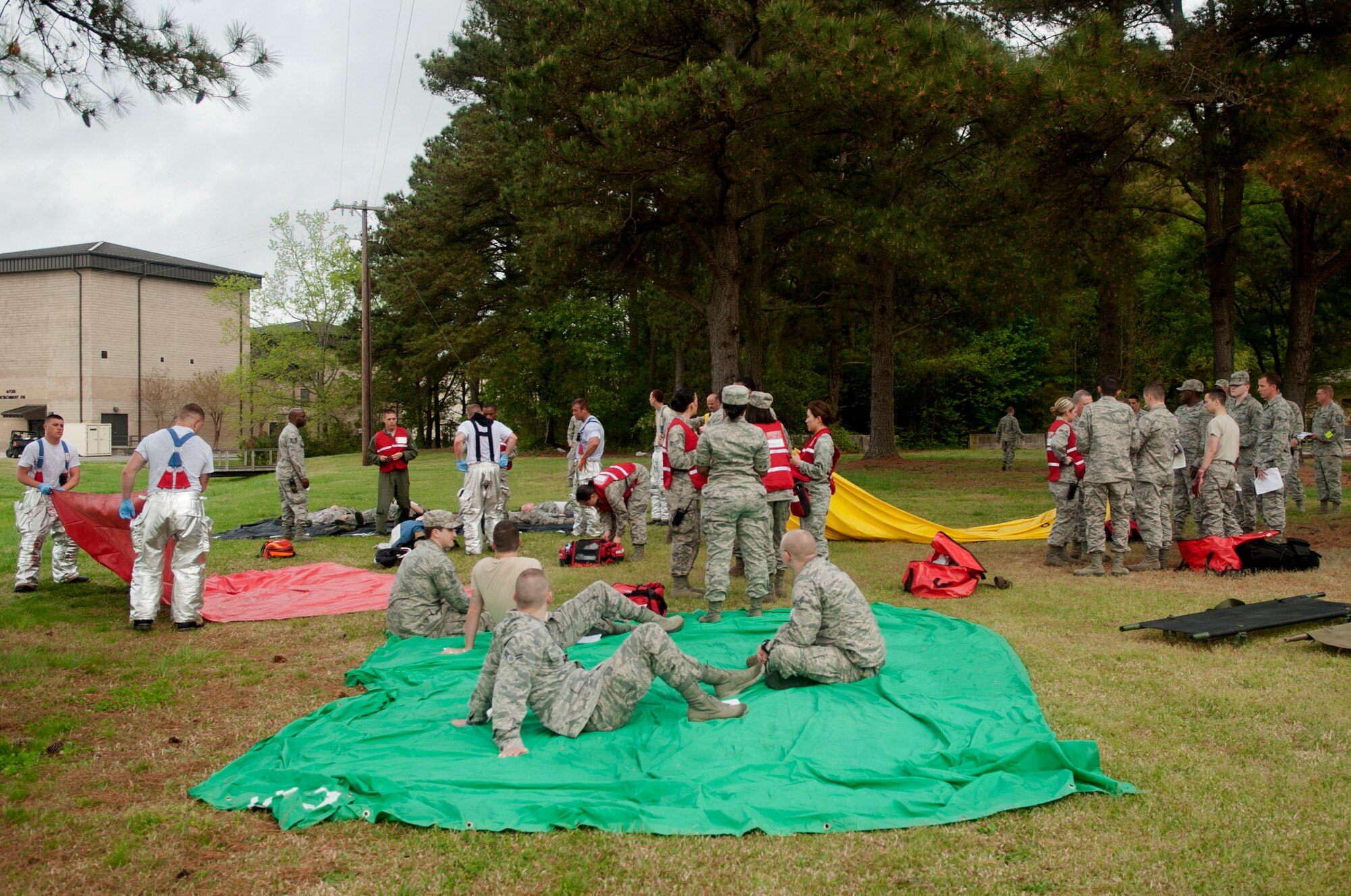 First responders from the 4th Medical Group and 4th Civil Engineer Squadron Fire Department triage simulated victims during a major accident response exercise, April 14, 2015, at Seymour Johnson Air Force Base, North Carolina. Victims were placed on different colored tarps corresponding to the criticality of their condition in order to be easily identified by first responders and treated accordingly. (U.S. Air Force photo/Airman Shawna L. Keyes)