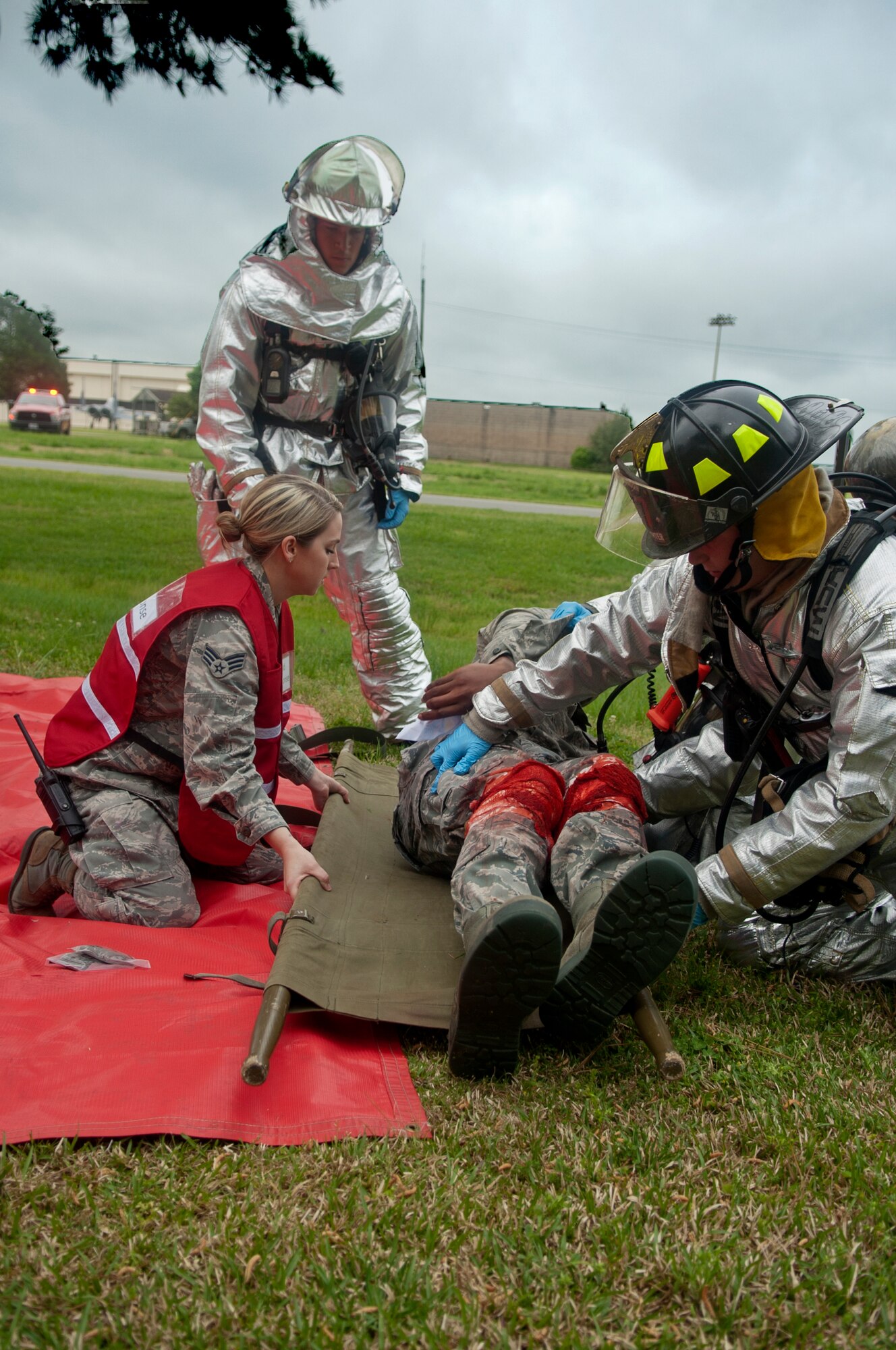 Airmen from the 4th Civil Engineer Squadron Fire Department and 4th Medical Group attend a simulated victim during a major accident response exercise, April 14, 2015, at Seymour Johnson Air Force Base, North Carolina. Base personnel acted as victims and wore special makeup, or moulage, to simulate life-like injuries and make the training more realistic. The victims were provided with notecards giving them instructions on how to portray their wounds or illnesses and to help emergency response personnel verify their condition in order to provide the correct treatment. (U.S. Air Force photo/Airman Shawna L. Keyes)
