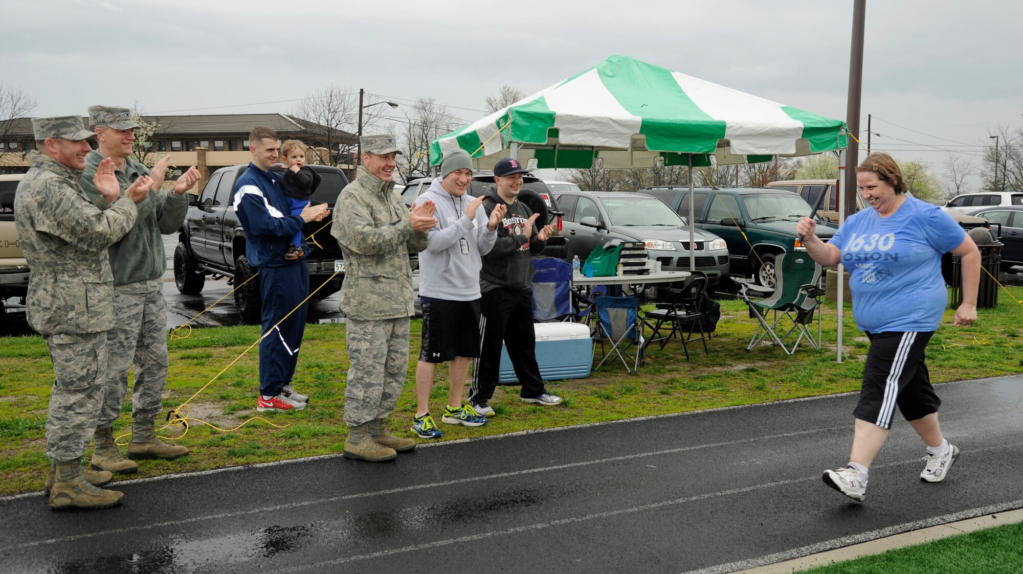 Col. Brad Hogland, 11th Wing commander, Col. Dan Waters, 11th WG vice commander, Chief Master Sgt. Vance Kondon, 11th WG command chief, and other Joint Base Andrews members cheer on Valerie Lewis, Air Force District of Washington Military Personnel Appropriations program manager, as she finishes a Holocaust remembrance vigil run April 14, 2015, on Joint Base Andrews, Md. Fifty-nine JBA members volunteered to run in shifts throughout the 24-hour vigil in honor of those who lost their lives during the Holocaust. (U.S. Air Force photo/Senior Airman Preston Webb)