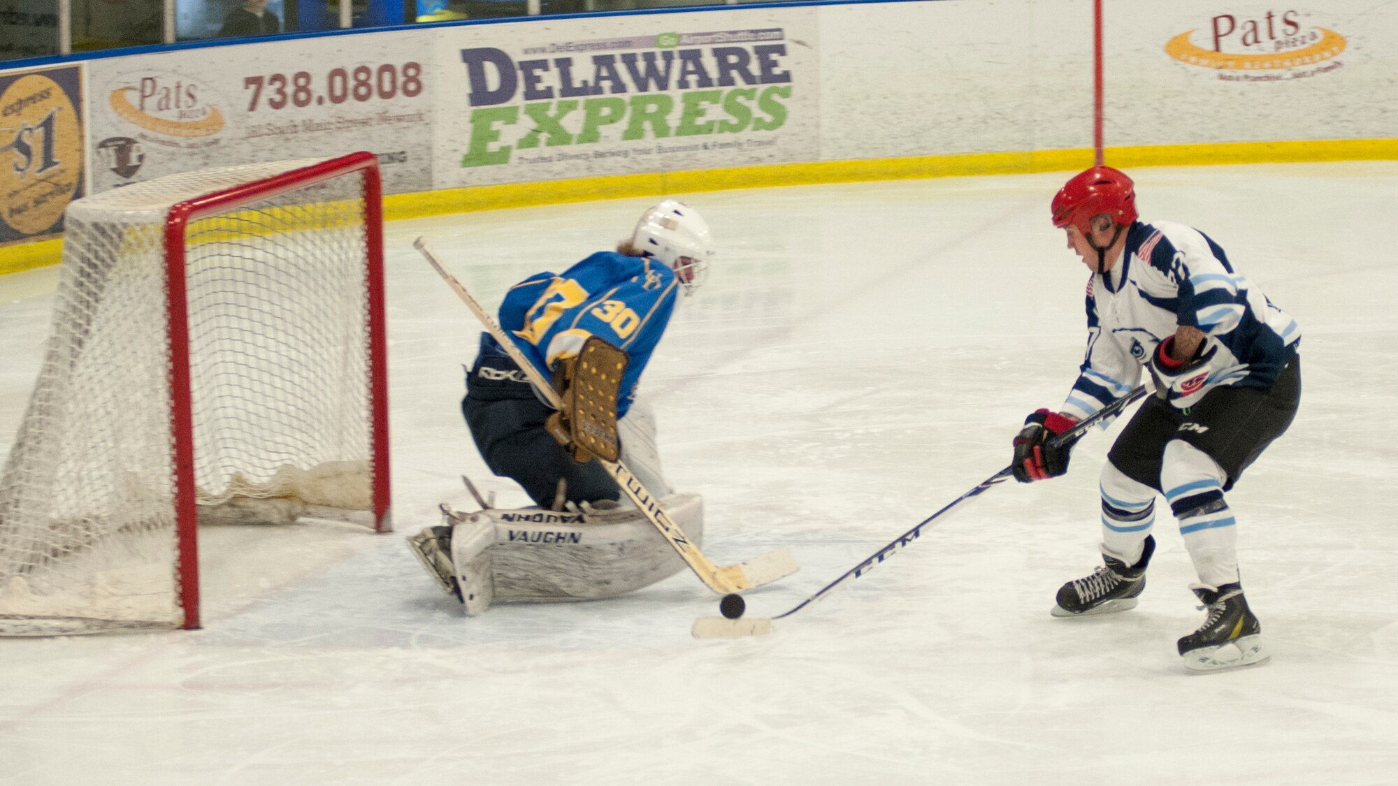 Davis Kokoszka, Dover Eagles defenseman, stick-handles the puck towards the goal April 11, 2015, at the Fred Rust Ice Arena on the University of Delaware campus in Newark, Del. The Dover Eagles consist of 13 Team Dover Airmen. The game was against the University of Delaware Blue Hens, American Collegiate Hockey Association men’s division 3, hockey team. (U.S. Air Force photo/Senior Airman Jared Duhon) 
