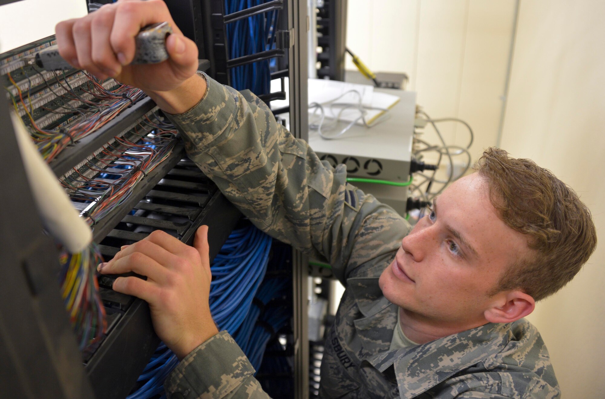 Airman 1st Class Avery Allsbury, assigned to the 205th Engineering Installation Squadron, terminates a 25-pair cable on a data rack patch panel during a real-world training opportunity on Tinker Air Force Base in Oklahoma City, April 11, 2015. Airmen with the 205th supported the 38th Cyberspace Engineering Installation Group by installing fiber optic cables for multiple networks used in real-world operations. (U.S. Air Force/ Tech. Sgt. Caroline Essex)