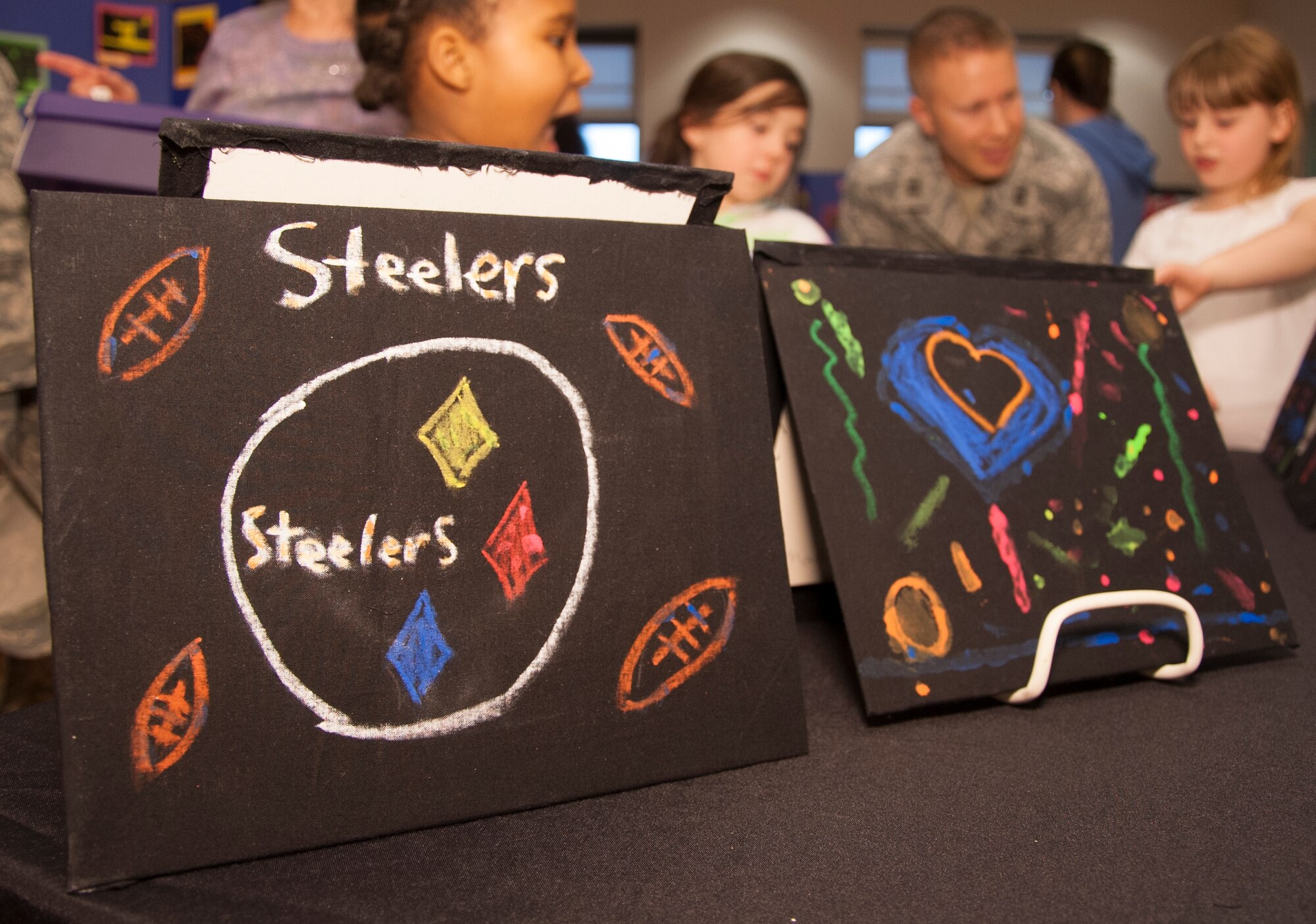 Glow-in-the-dark art work is displayed on a table during the grand opening April 7, 2015, at the Youth Center on Dover Air Force Base, Del. The glow-in-the-dark art work was made by children who are in the youth program. (U.S. Air Force photo/Senior Airman Jared Duhon)