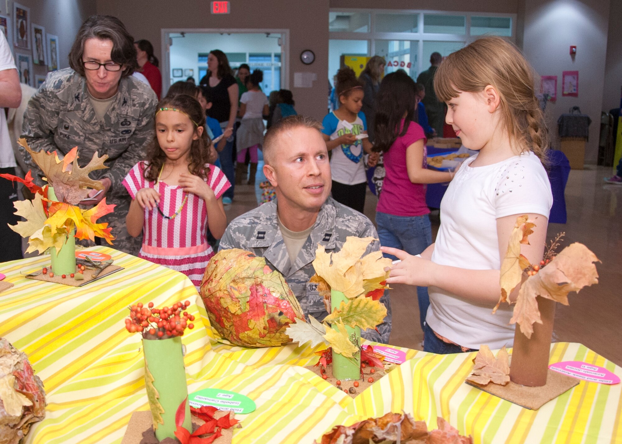 Col. Lisa Pike, 436th Mission Support Group commander, and Capt. Jake Wygant, 436th Force Support Squadron operations officer, are given a tour of the art exhibit during its grand opening April 7, 2015, at the Youth Center on Dover Air Force Base, Del. The event was put together to showcase the artwork of the children enrolled in the youth program (U.S. Air Force photo/Senior Airman Jared Duhon)