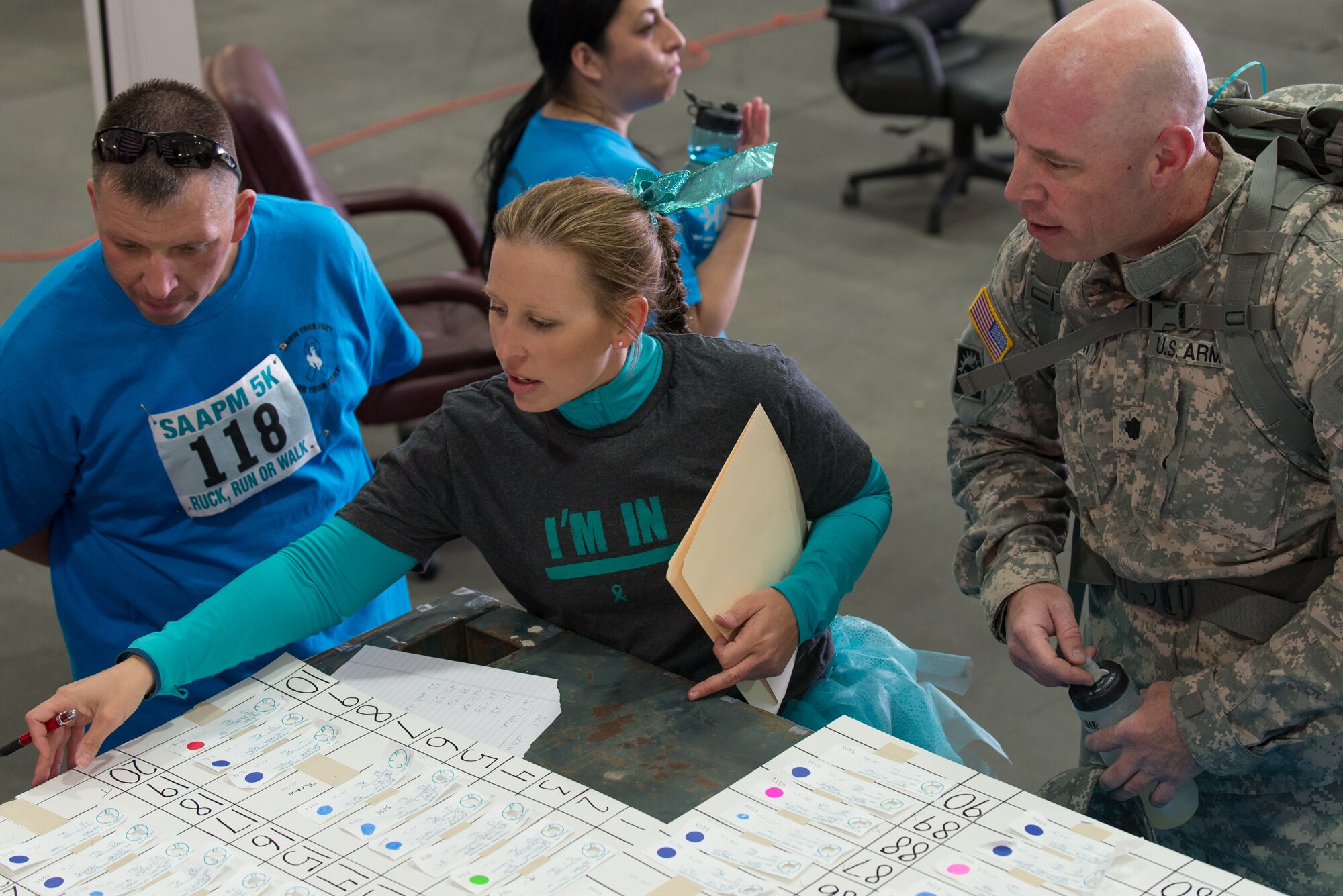 U.S. Air Force 1st Lt. Erin Swingholm, 153rd Airlift Wing Sexual Assault Prevention and Response Coordinator, Wyoming Air National Guard, reviews finishing times and placement of runners during a 5k ruck 5k run/walk, April 12, 2015, at Cheyenne Air National Guard Base in Cheyenne, Wyo. Swingholm organized a run to raise awareness for sexual assault awareness and prevention. (U.S. Air National Guard photo by Master Sgt. Charles Delano)