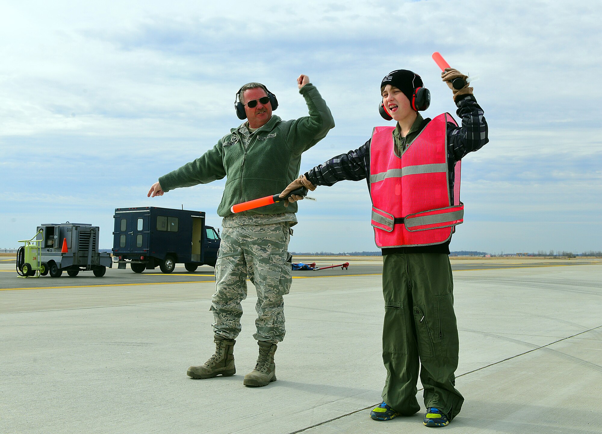 Senior Master Sgt. John Laibe, 121st Air Refueling Wing crew chief, instructs Ian Straight, a 12-year-old from Lancaster, Ohio, in the proper method of marshalling aircraft during a pilot for a day program March 19, 2015, at Rickenbacker Air National Guard Base, Ohio. The program treats a youth with chronic or life threatening illnesses to a day of military experiences. The 121st ARW has partnered with Nationwide Children’s Hospital to provide this opportunity. (U.S. Air National Guard photo by Master Sgt. Ralph Branson/Released)
