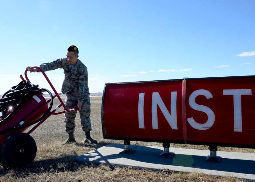 Airman 1st Class Justin Chung, 28th Operations Support Squadron airfield management coordinator, moves fire equipment off the flightline during an airfield inspection at Ellsworth Air Force Base, S.D., March 13, 2015. Airfield management personnel must ensure the airfield environment is clear of any obstructions that could pose a danger to personnel and aircraft operations. (U.S. Air Force photo by Senior Airman Anania Tekurio/Released)