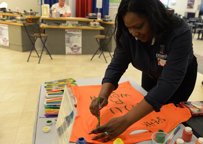 Common Orris, Base Exchange general manager, creates a tee-shirt in support of Project Clothesline at the Base Exchange on April 13, 2015 at Joint Base Charleston, SC. Project Clothesline is a way for people affected by domestic abuse to express their feelings by decorating a tee-shirt and hanging it in a public area to encourage other victims to break the silence.  (U.S. Air Force Photo/Senior Airman Ericka Engblom)
