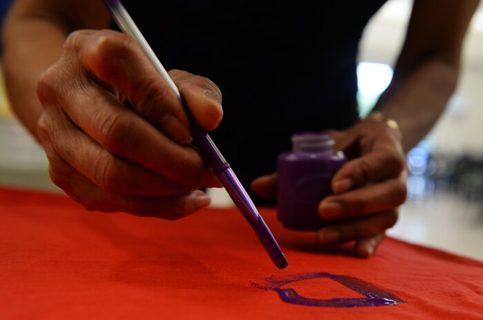 A Base Exchange employee creates a tee-shirt in support of Project Clothesline at the Base Exchange on April 13, 2015 at Joint Base Charleston, SC. Project Clothesline is a way for people affected by domestic abuse to express their feelings by decorating a tee-shirt and hanging it in a public area to encourage other victims to break the silence.  (U.S. Air Force Photo/Senior Airman Ericka Engblom)
