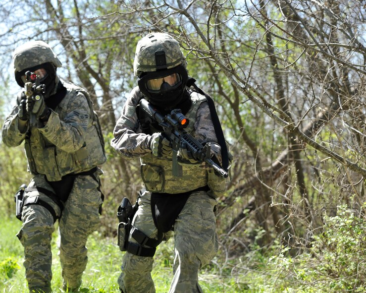 Two Security Forces defenders scan the area for targets during a live-fire exercise at Laughlin Air Force Base, Texas, March 28, 2015. Defenders worked in teams of two or more to navigate an area and take down their targets. (U.S. Air Force photo by Staff Sgt. Nathan Maysonet)(Released)