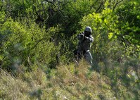 An Airman fires his weapon from behind concealment at Laughlin Air Force Base, Texas, March 28, 2015. Simulator rounds were used to during the training exercise to help Laughlin defenders become familiar with immediate action procedures. (U.S. Air Force photo by Staff Sgt. Nathan Maysonet)(Released)