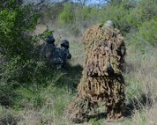 Airmen 1st Class, Clarissa Duley and Dianna Shigeta, 47th Security Forces Squadron defenders, get ambushed by Senior Airman Daniel Miller, 47th SFS unit trainer, at Laughlin Air Force Base, Texas, March 28, 2015. During a security forces live-fire exercise, defenders learned to use teamwork, communication, and situational awareness to overcome their challenge. (U.S. Air Force photo by Airman 1st Class Jimmie D. Pike)(Released)