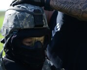 Airman 1st Class Dianna Shigeta, 47th Security Forces Squadron patrolman, gets her helmet fitted over her mask at Laughlin Air force Base, Texas, March 28, 2015. Helmets, facemasks, body armor and other protective equipment were used to reduce the probability of injuries. (U.S. Air Force photo by Airman 1st Class Jimmie D. Pike)(Released)