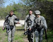 From left to right, Senior Airmen Collin Madison, Johnathan Mansfield and Kevin Moppert, 47th Security Forces Squadron defenders, discuss their run through during a live-fire exercise at Laughlin Air Force Base, Texas, March 28, 2015. During the exercise teams would navigate through a trail shooting at targets, before facing off against two shooters in an ambush scenario. (U.S. Air Force photo by Airman 1st Class Jimmie D. Pike)(Released)