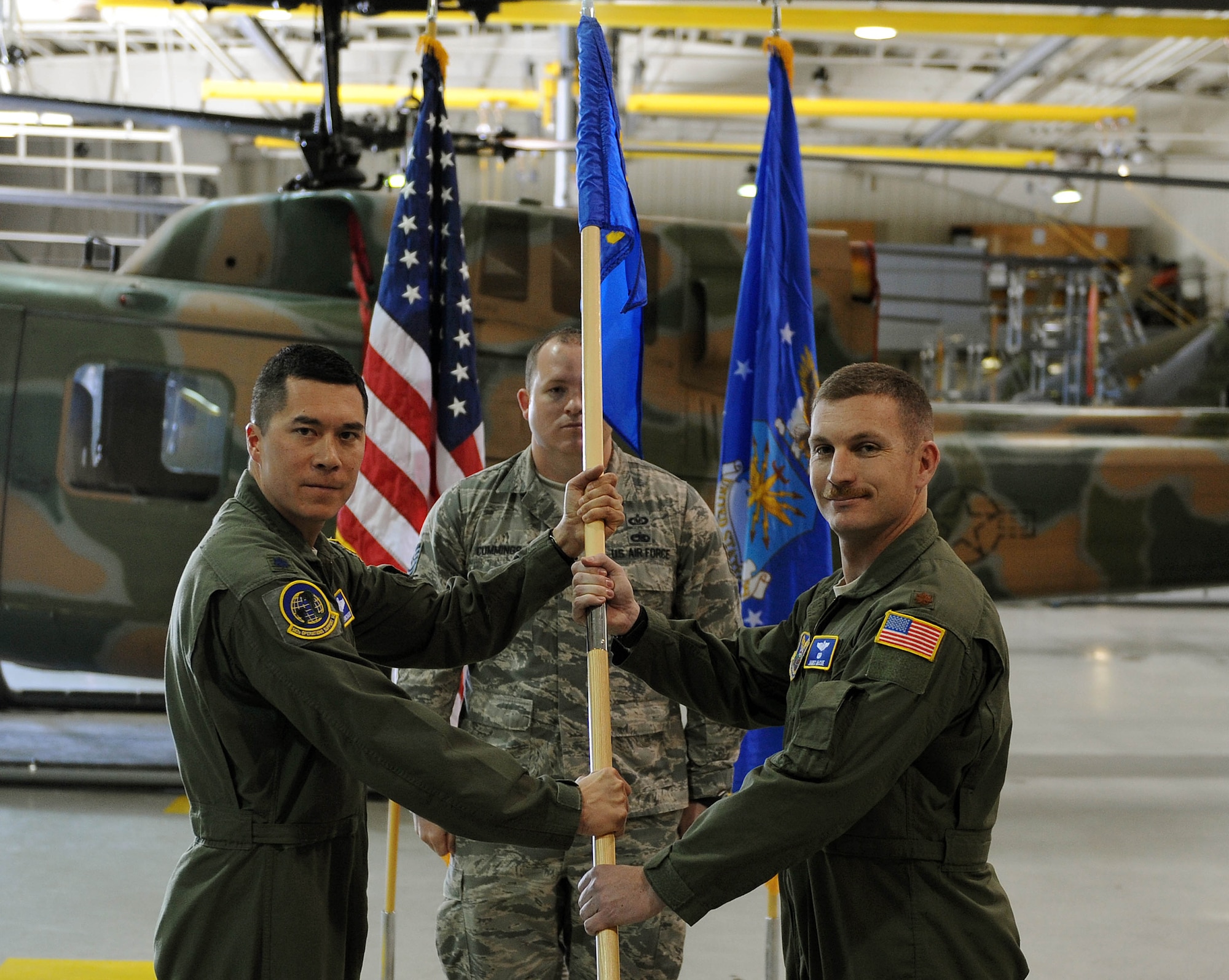 Lieutenant Colonel James S. Blanchard, 582nd Operations Support Squadron commander, passes the 582nd OSS, Detachment 4, guidon to Major James R. McCue, 582nd OSS, Det. 4 commander during an assumption of command ceremony at Minot Air Force Base, N.D., April 9, 2015. The 582nd OSS will report to the first ever Air Force group that was activated March of this year at 20th Air Force. (U.S. Air Force photo/Senior Airman Kristoffer Kaubisch)
