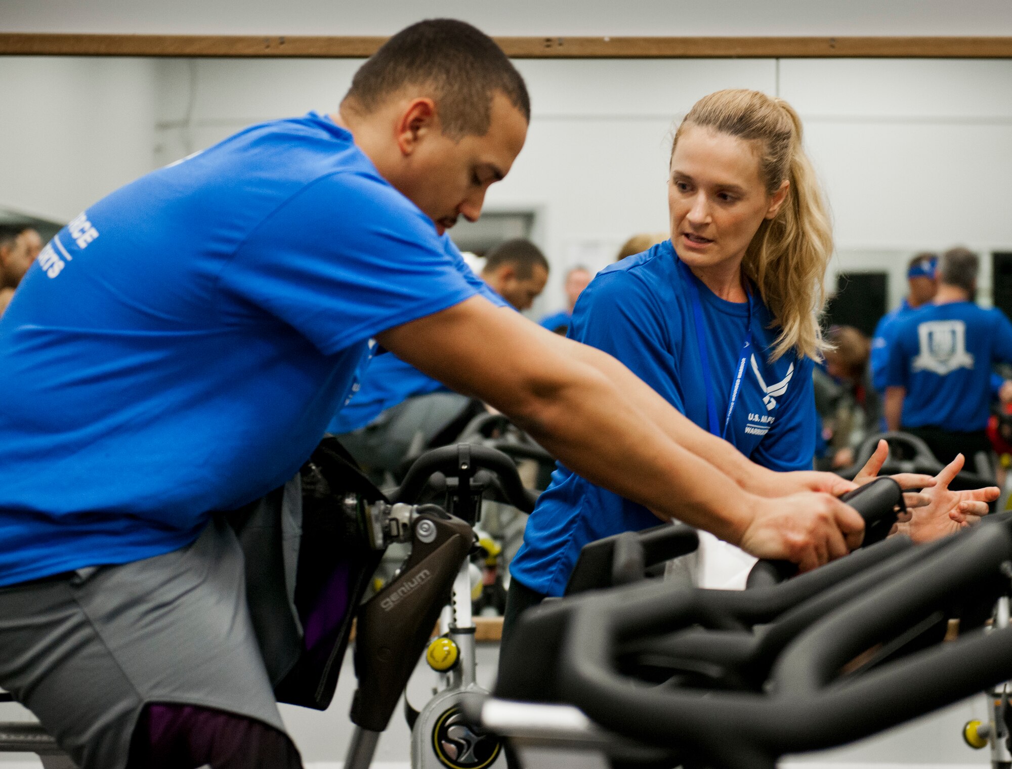 Kristin Hench, an Air Force Wounded Warrior coach, helps a Wounded Warrior get comfortable on a stationary bike during the first day of an introductory adaptive sports and rehabilitation camp at Eglin Air Force Base, Fla., April 13. The DOD’s military adaptive sports program enhances warrior recovery by engaging wounded, ill and injured service members in ongoing, daily adaptive activities, based on their interest and ability.  (U.S. Air Force photo/Samuel King Jr.)