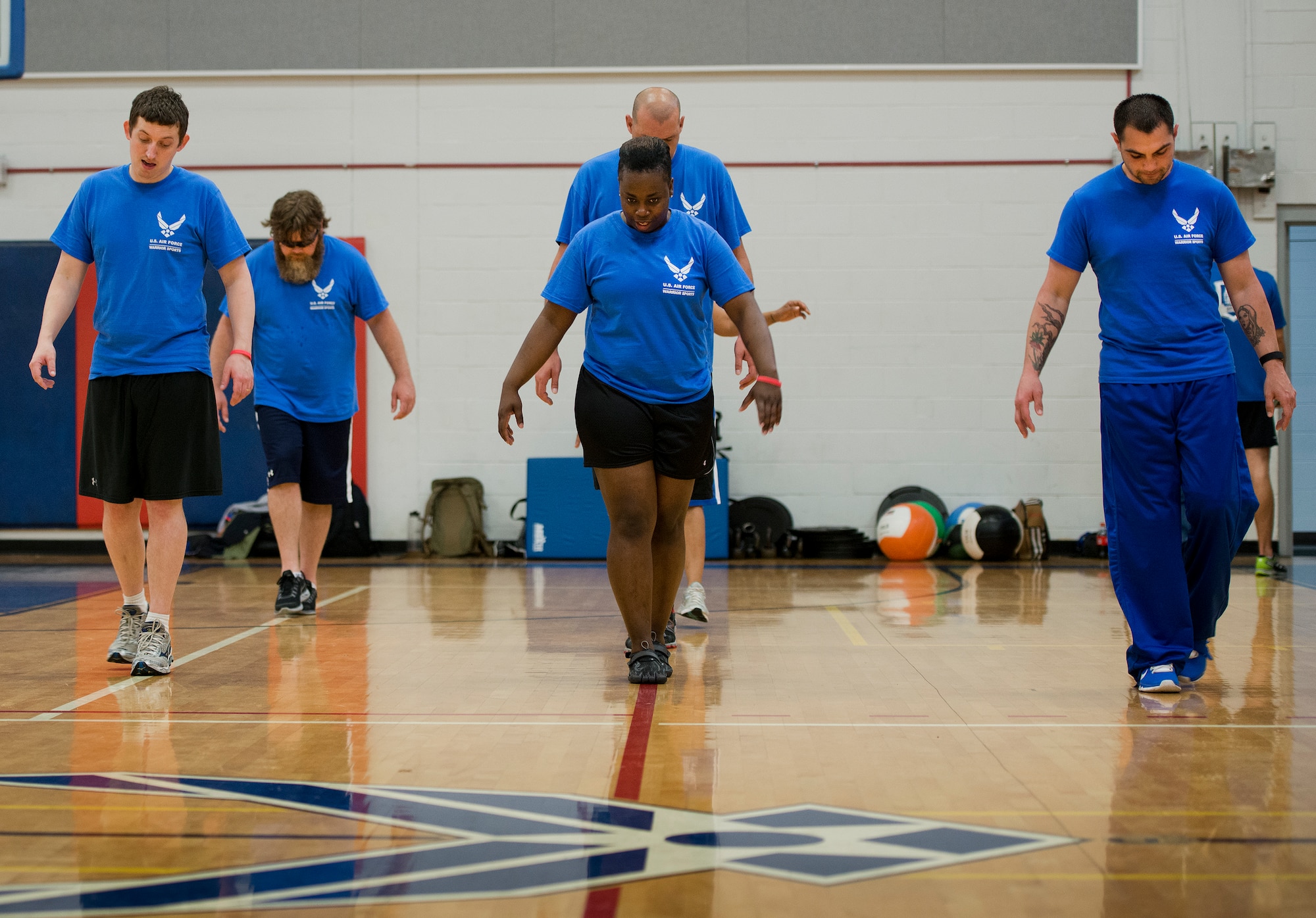 A group of Air Force Wounded Warrior athletes take small steps along a straight line during the first day of an introductory adaptive sports and rehabilitation camp at Eglin Air Force Base, Fla., April 13. The DOD’s military adaptive sports program enhances warrior recovery by engaging wounded, ill and injured service members in ongoing, daily adaptive activities, based on their interest and ability.  (U.S. Air Force photo/Samuel King Jr.)