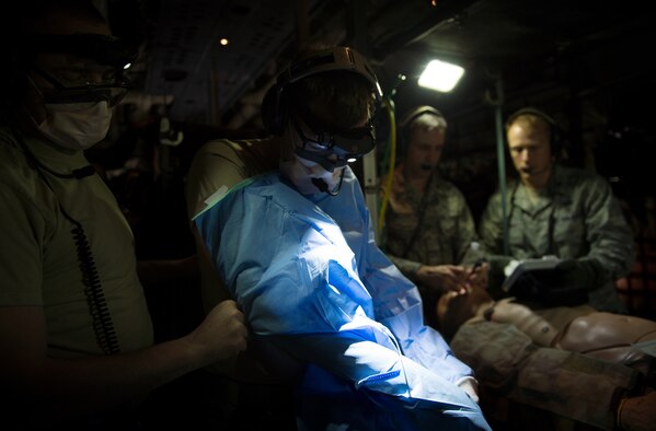 Capt. Dallas Hansen, an 86th Medical Squadron surgeon with Tactical Critical Care Evacuation Team - Enhanced, known as “TCCET-E” for short, performs a mock in-flight surgery during a training flight with the 86th Aeromedical Evacuation Squadron March 26, 2015, above Ramstein Air Base, Germany. The exercise scenario was performed on board a 37th Airlift Squadron C-130J Super Hercules to help perfect the potentially new TCCET-E capability which gives the 86th AES and flight surgeons the ability to do quick, critical surgeries as fast as possible while in transit to a hospital. (U.S. Air Force photo/Staff Sgt. Sara Keller) 