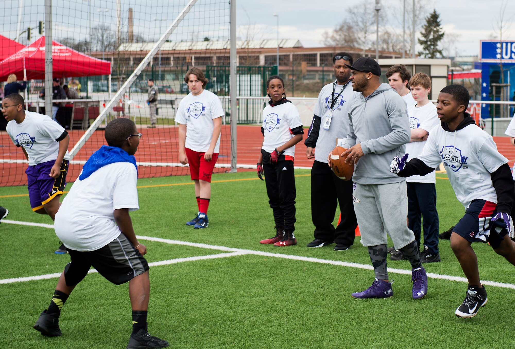 Steve Smith, Baltimore Ravens wide receiver, looks for an open teammate to pass the ball to during a ProCamps event April 11, at Vogelweh Military Complex, Germany. Smith, three-time All-Pro NFL wide receiver, played all-time quarterback during the camp, jumping into different scrimmages to throw touchdown passes to children. (U.S. Air Force photo/Senior Airman Damon Kasberg)