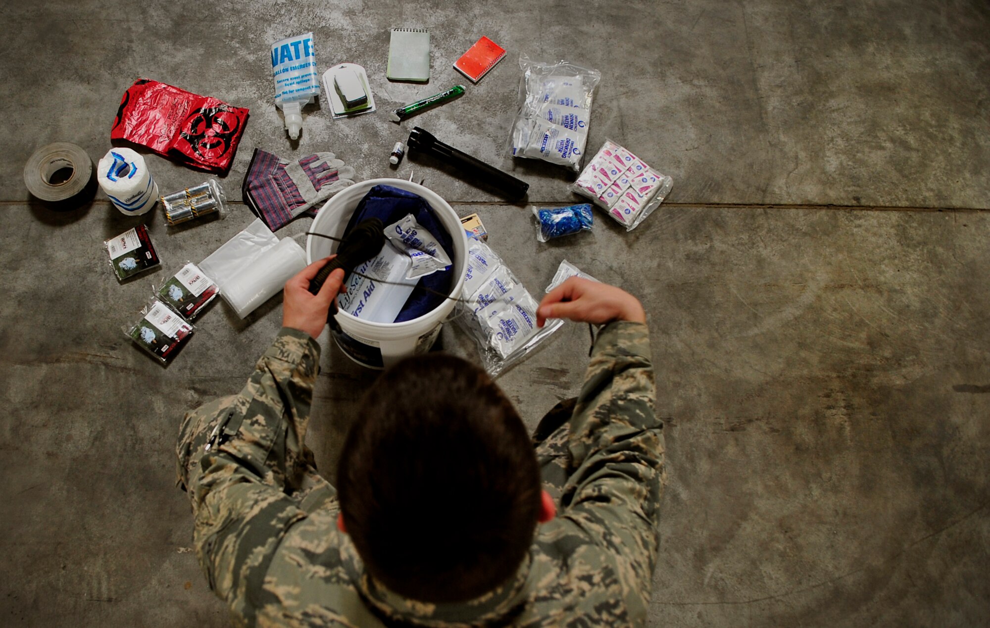Airman 1st Class Robert Ridgway, 786th Civil Engineer Squadron plans and operations, goes through an emergency preparedness kit April 13, 2015, at Ramstein Air Base, Germany. The kits consist of items to sustain individuals and families for 72 hours. The 786th CES Airmen also suggest including canned goods in the kits. (U.S. Air Force photo/Airman 1st Class Larissa Greatwood) 