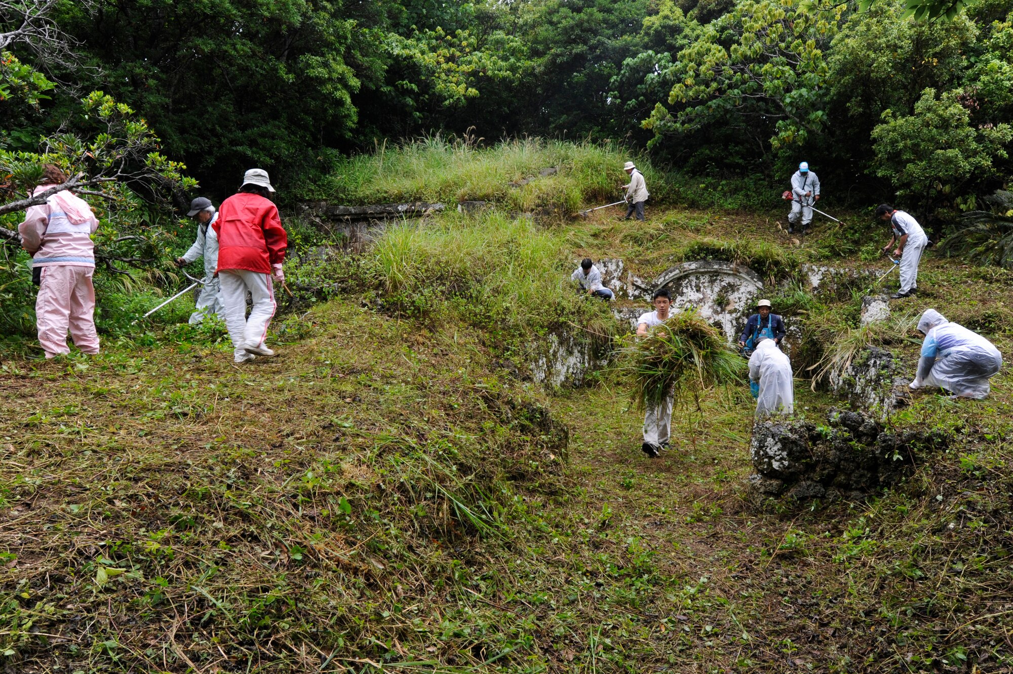 Okinawans clear overgrown plants from the area surrounding their family tomb in preparation for Shimi at Kadena Air Base, Japan, April 12, 2015. Shimi is an annual celebration on Okinawa, during which family tombs and the surrounding areas are cleaned before extended family members gather to pray and offer food to their ancestors. More than 400 locals visited the base this year to pray, eat and enjoy each other’s company. (U.S. Air Force photo by Staff Sgt. Marcus Morris)